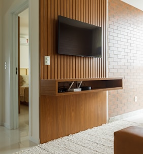 a flat screen tv mounted on a wooden wall
