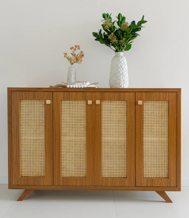 Rattan side cabinet showcasing woven texture and decorative items on top.