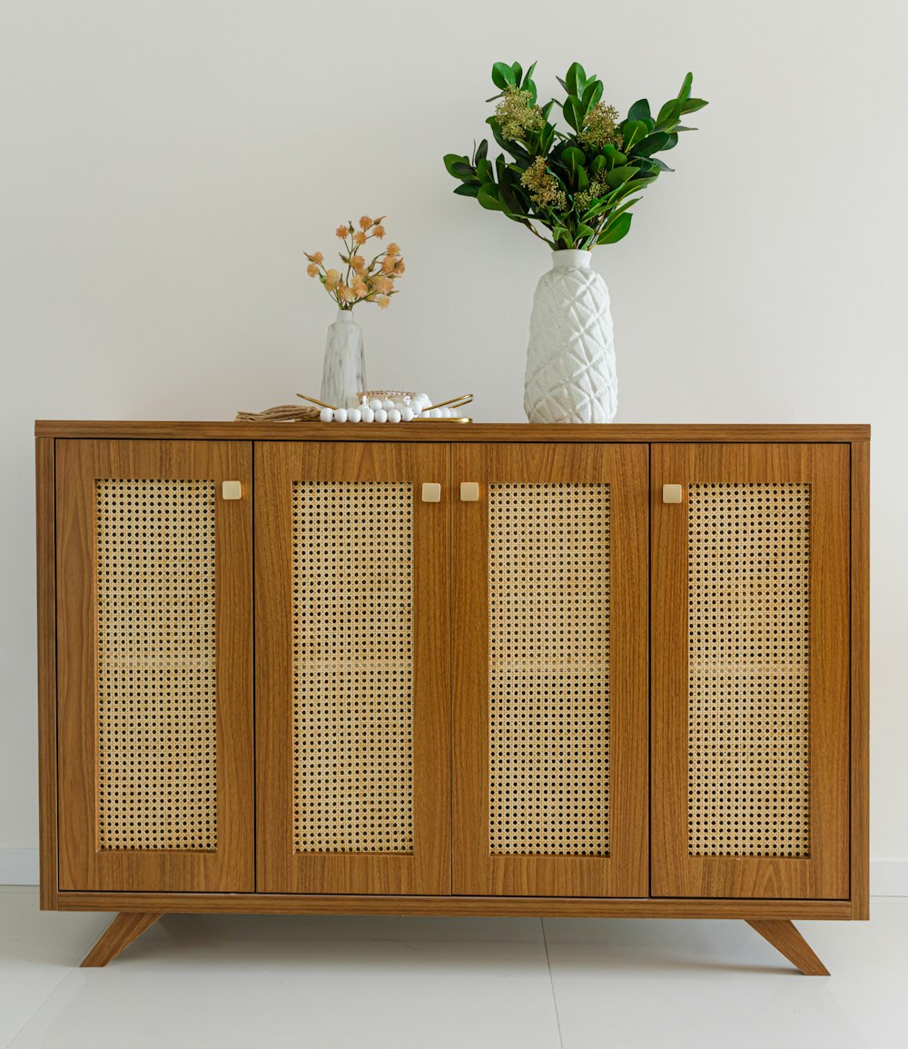 a wooden cabinet with a vase of flowers on top of it