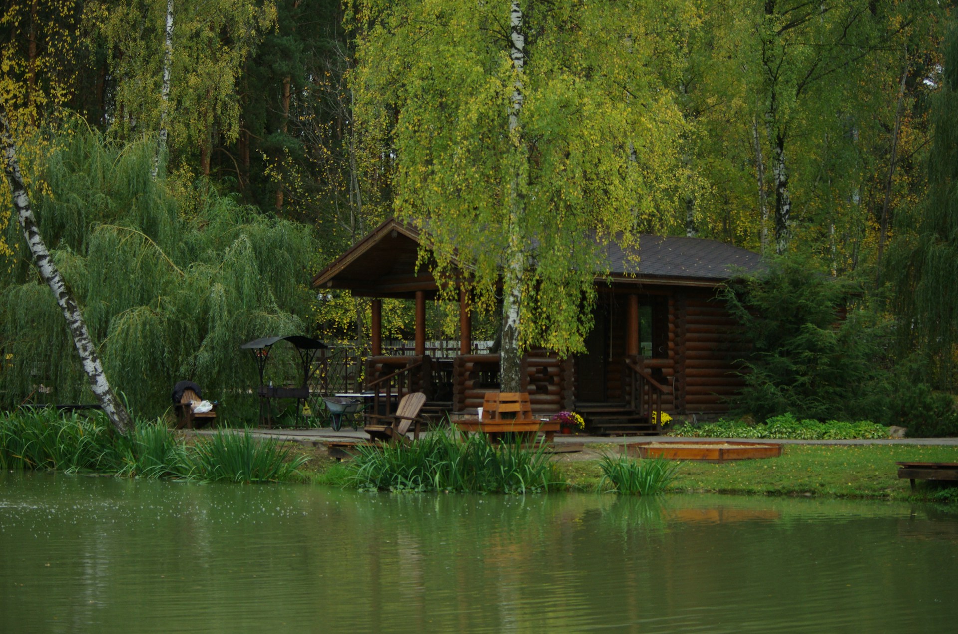 a log cabin sits on the shore of a lake