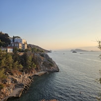 Cozy summer house nestled among lush greenery near the Limfjord shore at sunset.