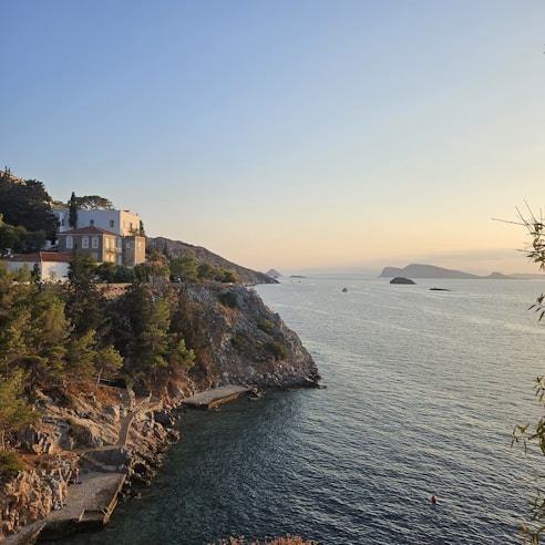Cozy summer house nestled among lush greenery near the Limfjord shore at sunset.