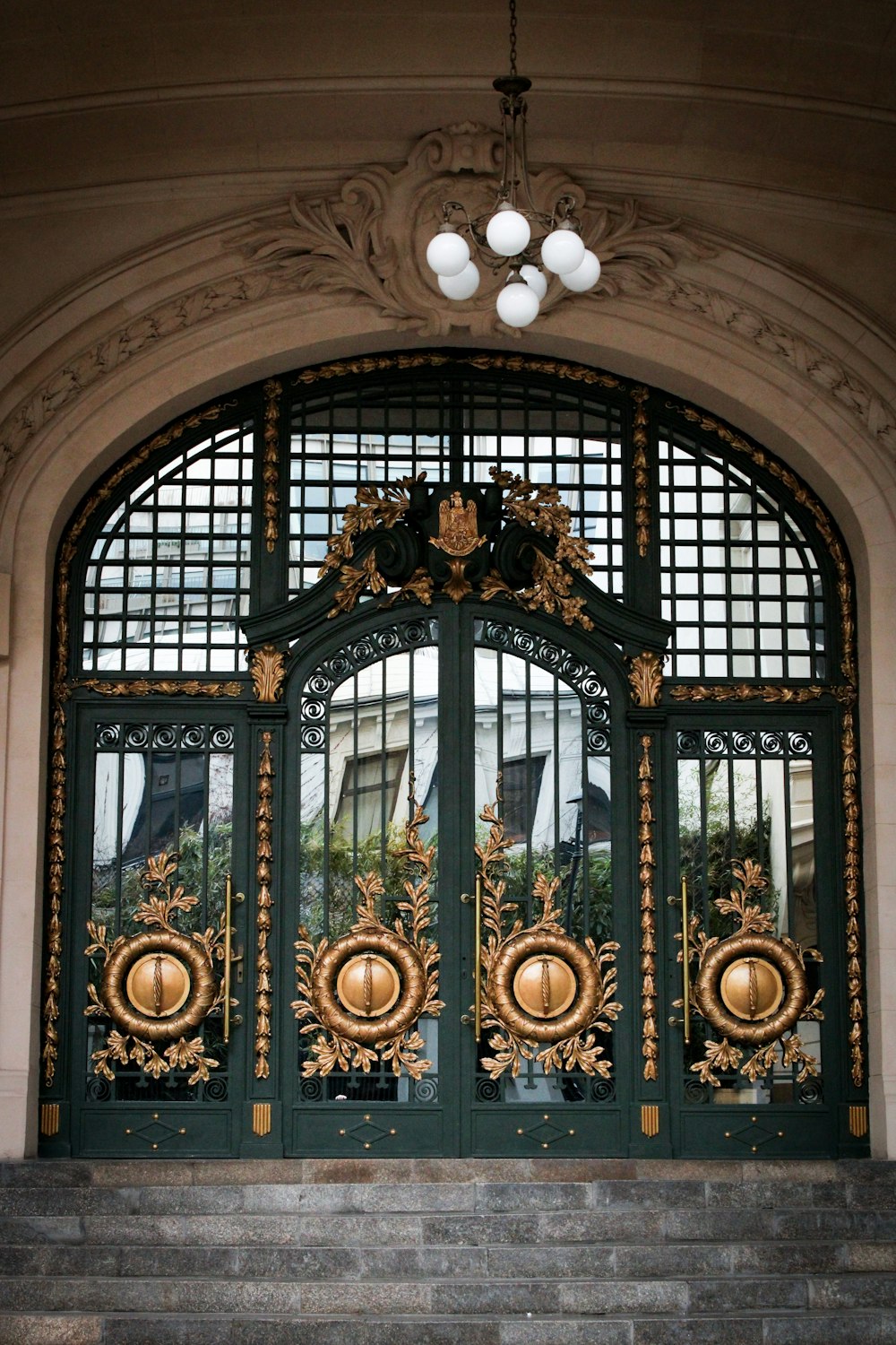 a large green door with gold decorations on it