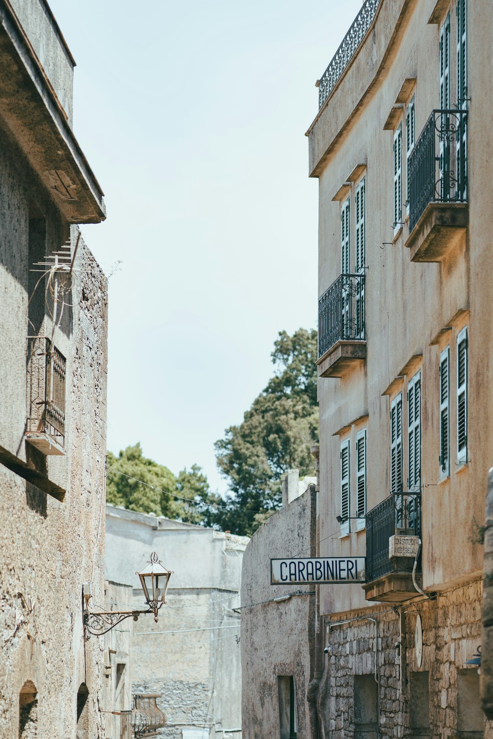 a narrow alleyway between two buildings with balconies