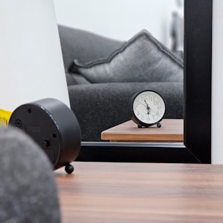 a clock sitting on top of a wooden table