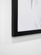 Close-up of a minimalist black and white print framed in sleek black wood.