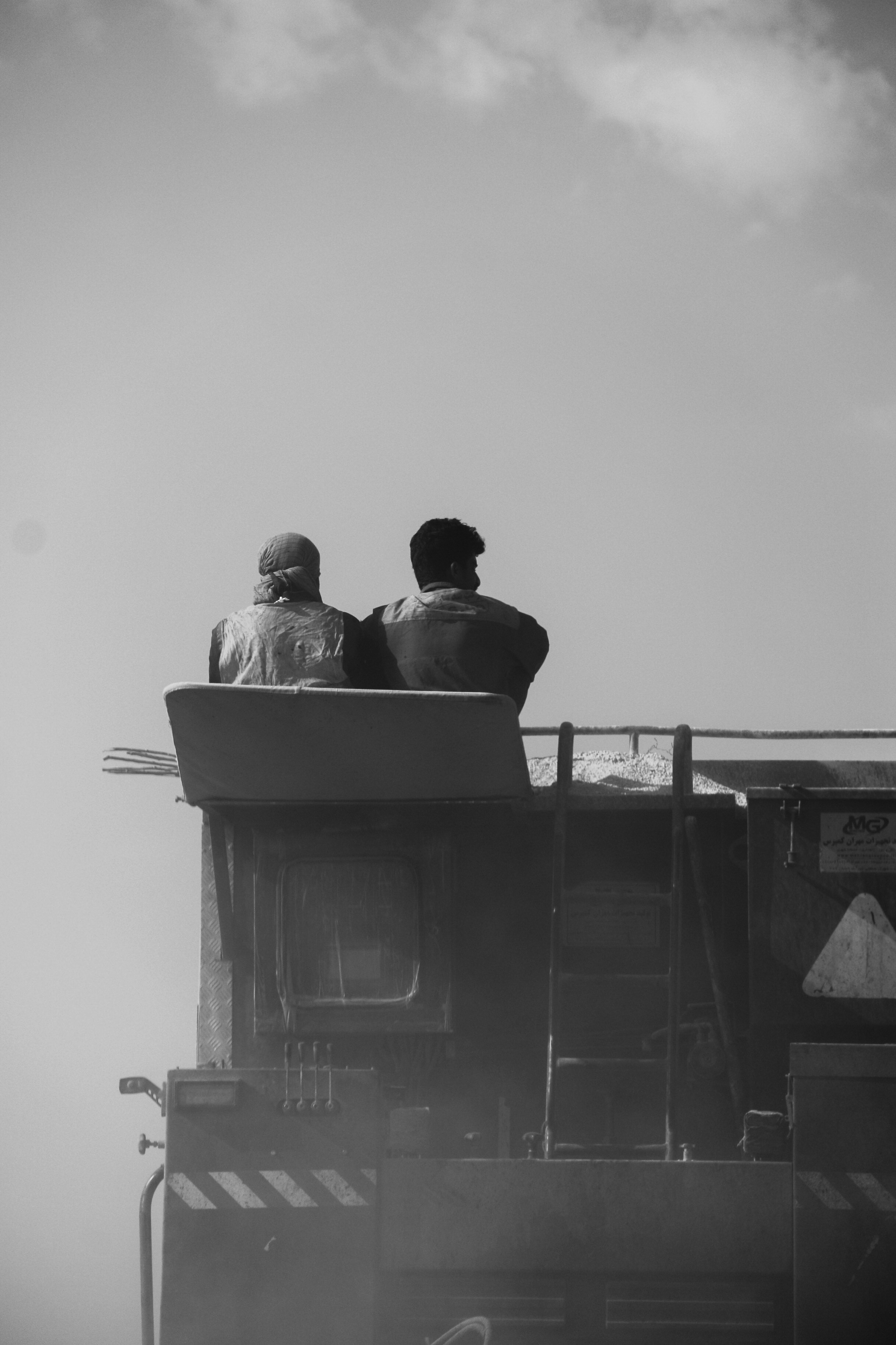 two people sitting on top of a train
