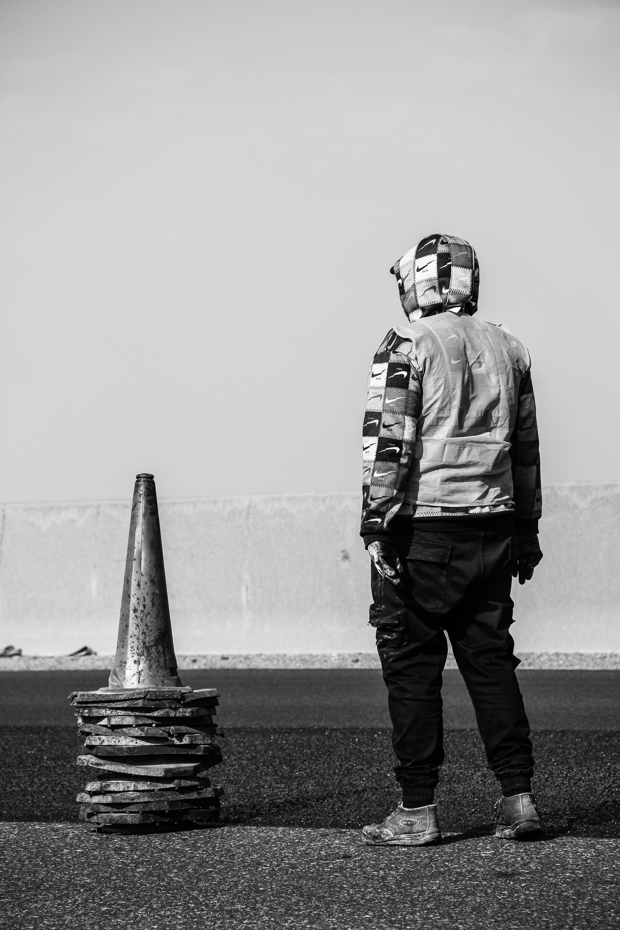 a man standing next to a traffic cone