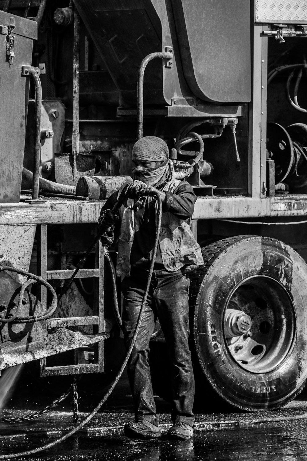 a black and white photo of a man washing a truck