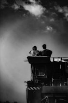 a couple of people sitting on top of a truck