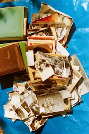 a pile of old photos and books on a blue tarp