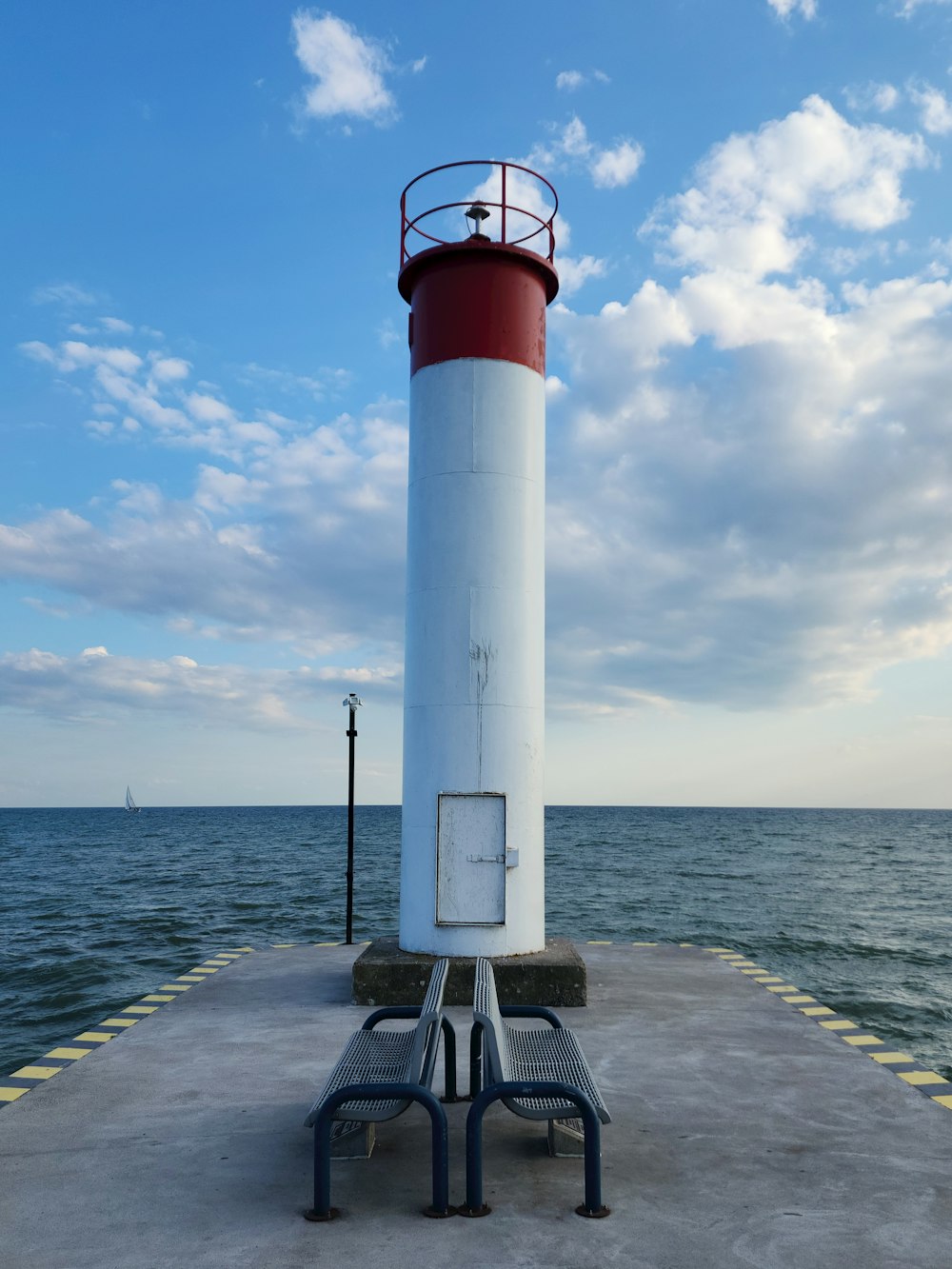 a red and white light house sitting on top of a pier