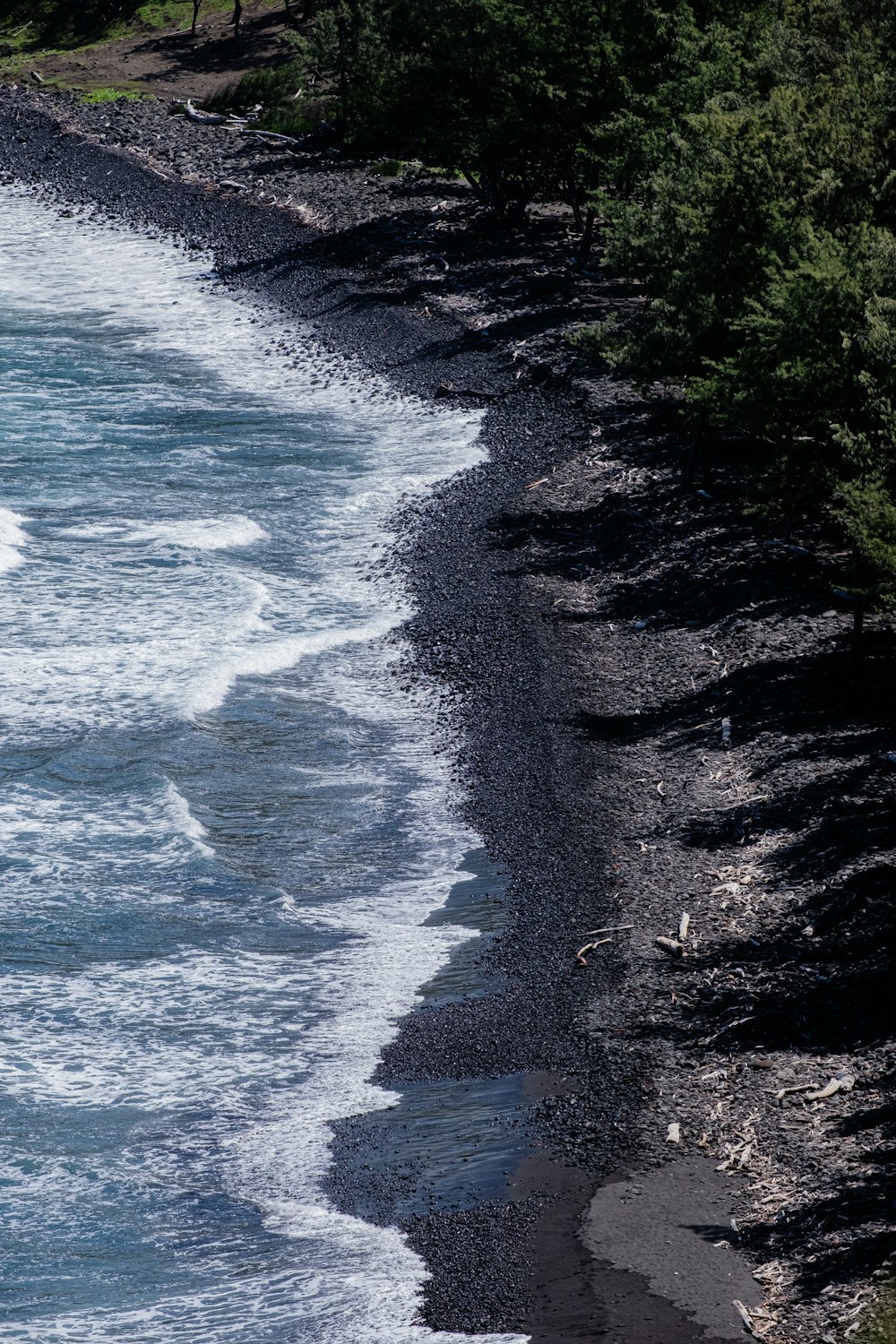 a black sand beach next to the ocean