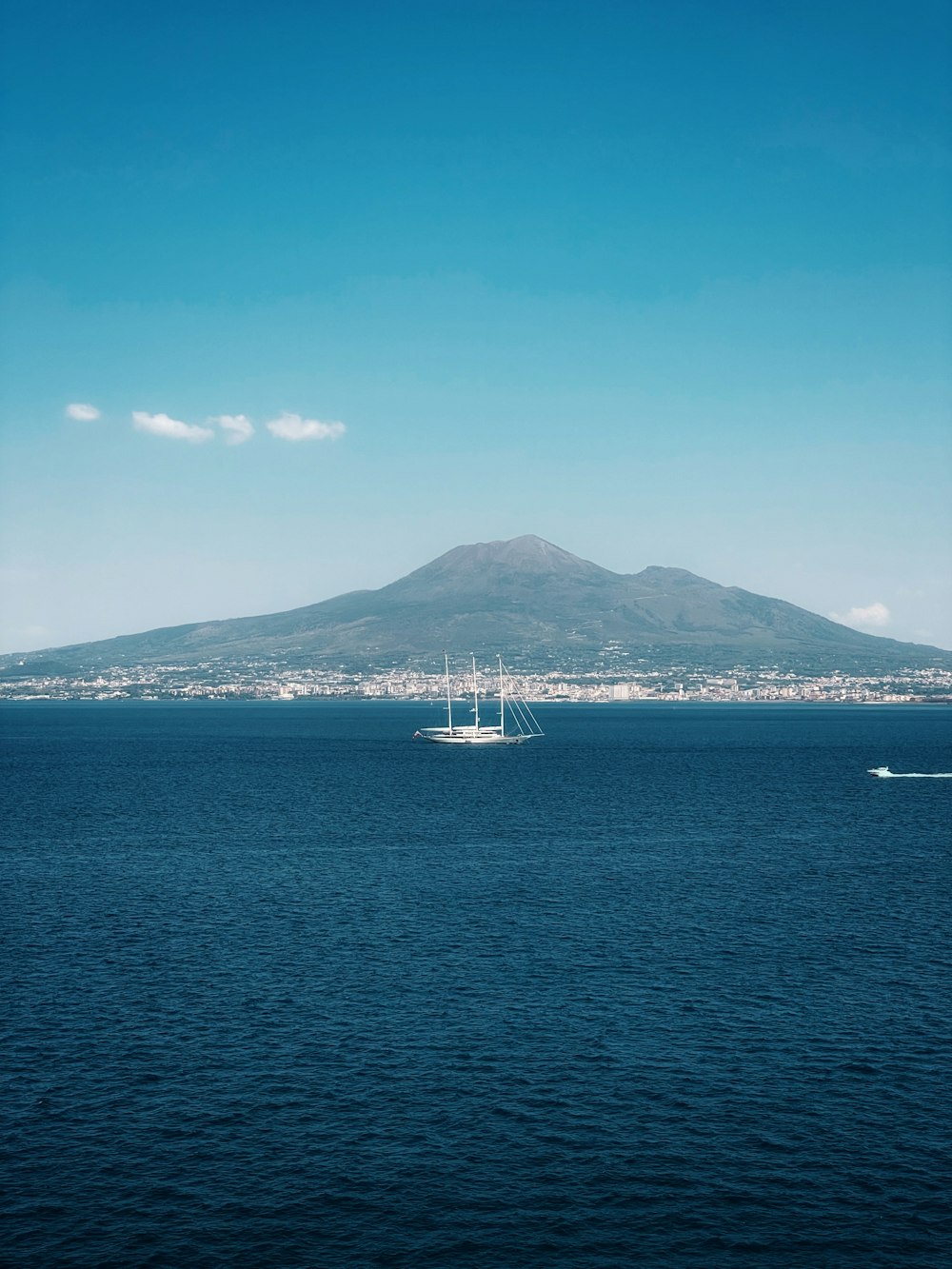 a large body of water with a mountain in the background