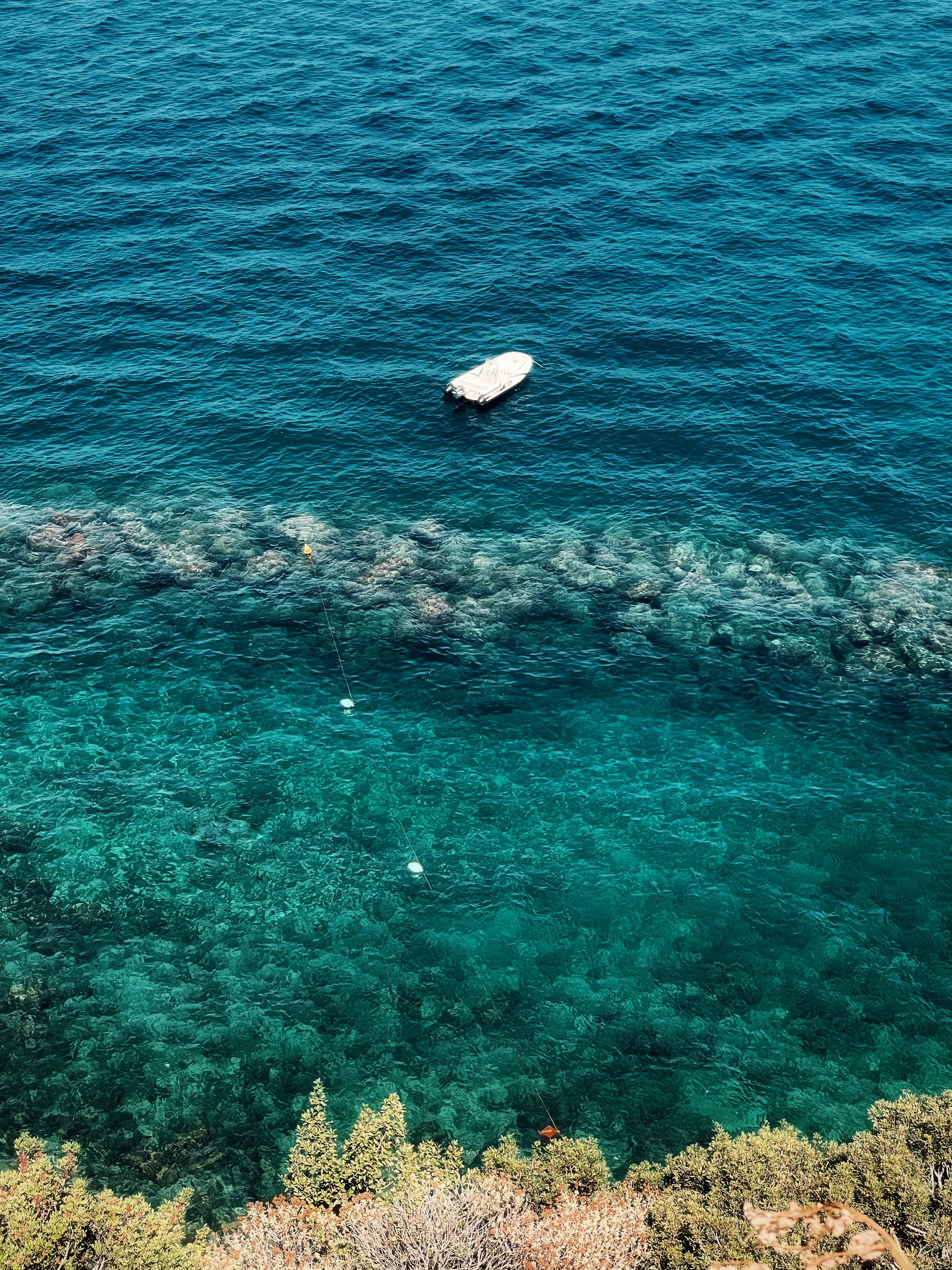 ein weißes Boot, das mitten auf einem Gewässer treibt