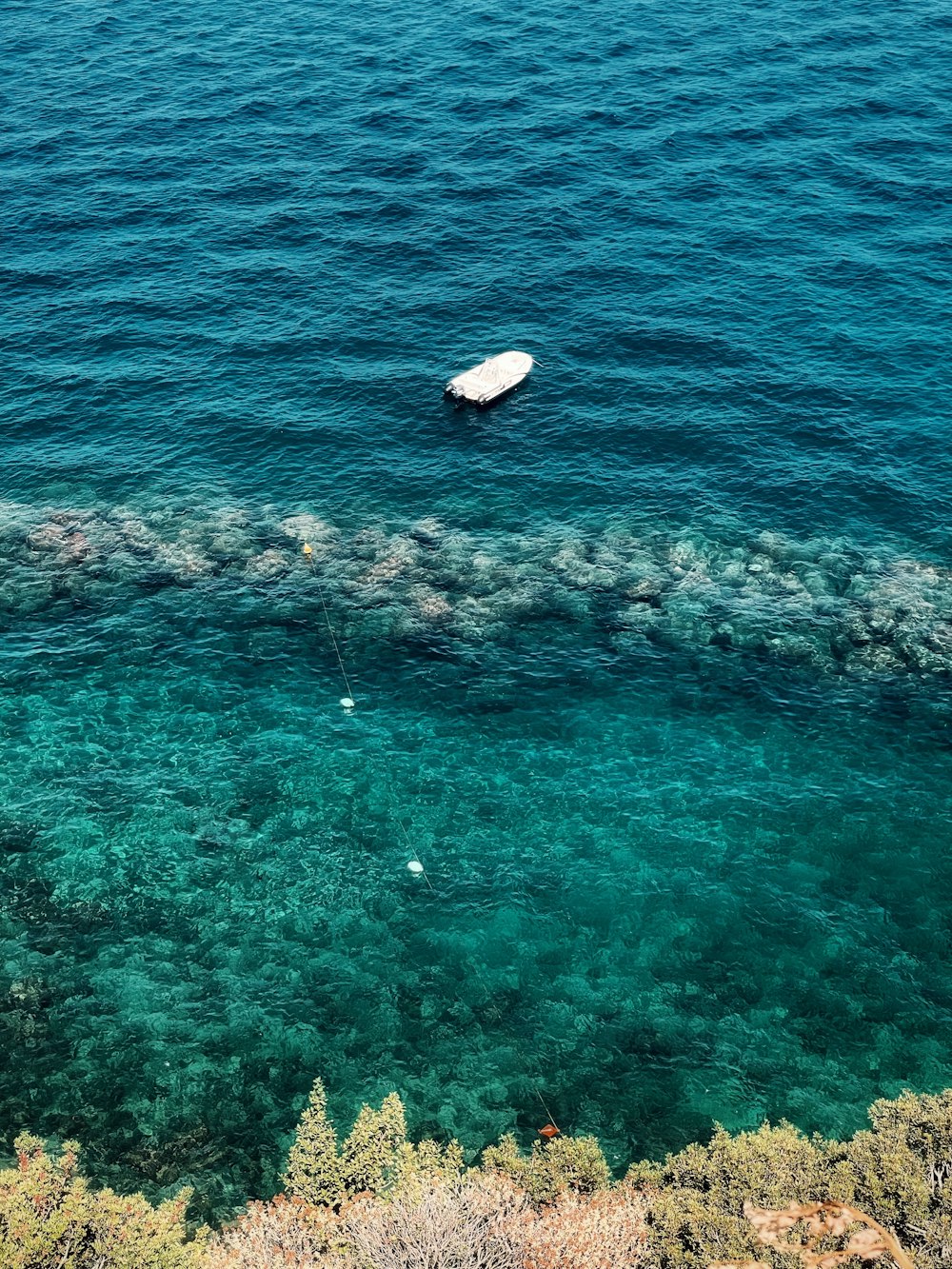 a white boat floating in the middle of a body of water