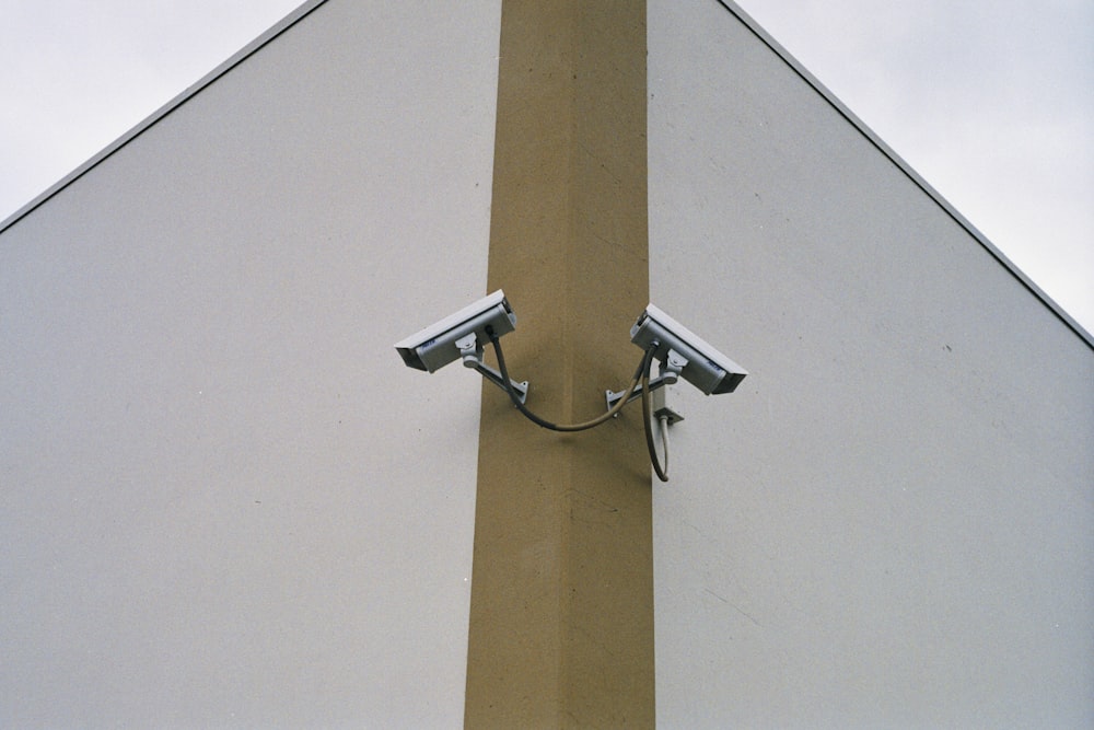 two security cameras mounted to the side of a building