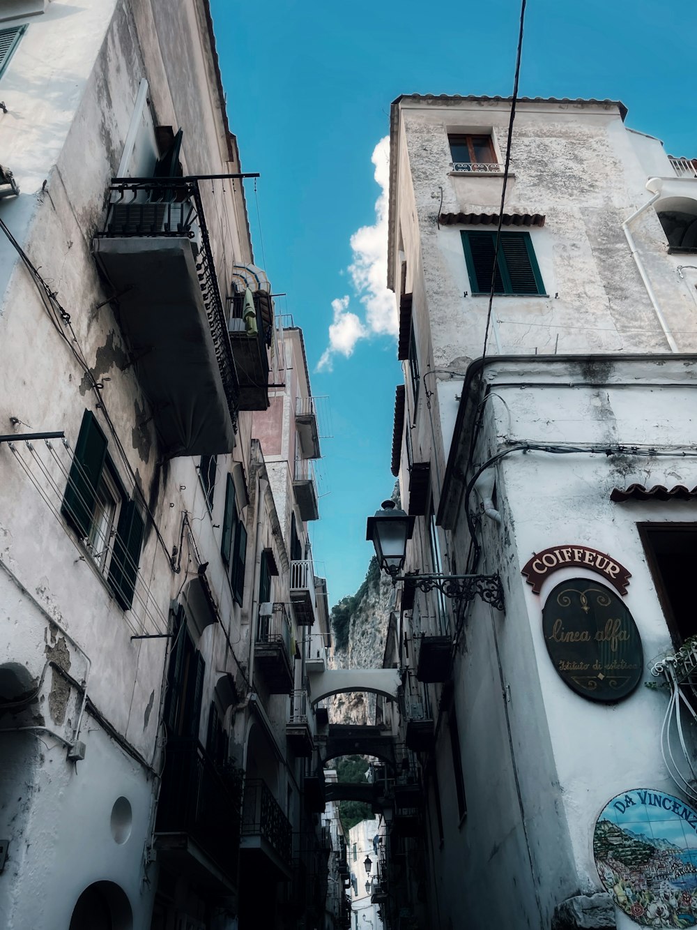 a narrow alleyway between two buildings on a sunny day