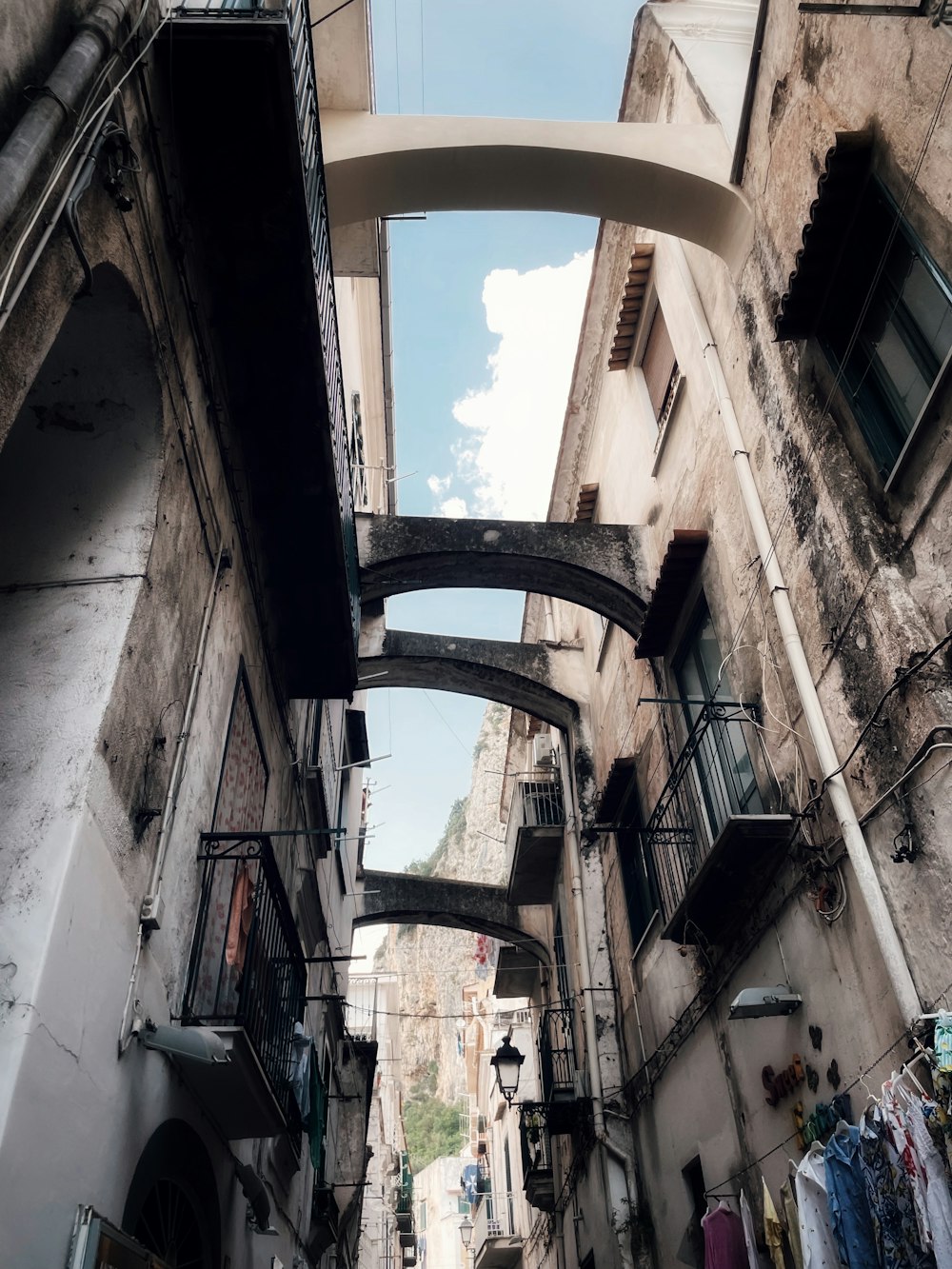 a narrow alleyway with clothes hanging from the buildings