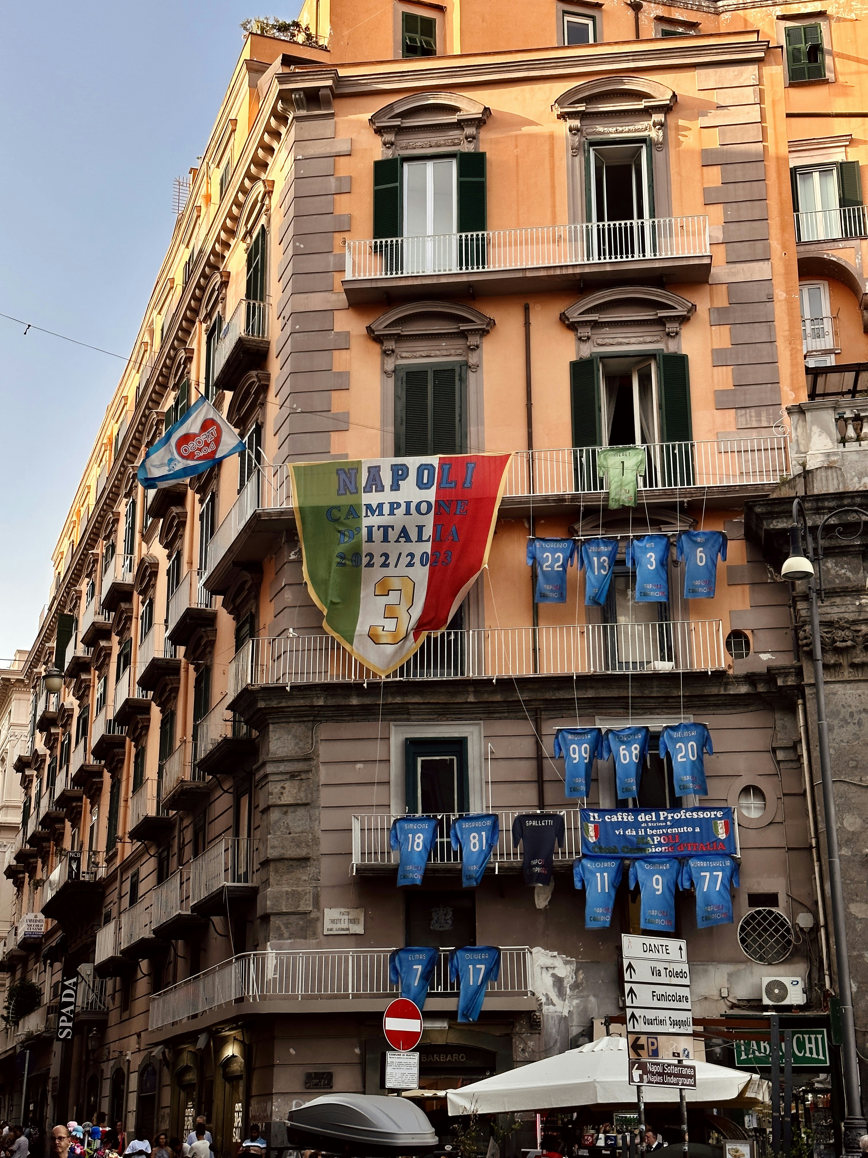 a tall building with a bunch of flags hanging from it's sides