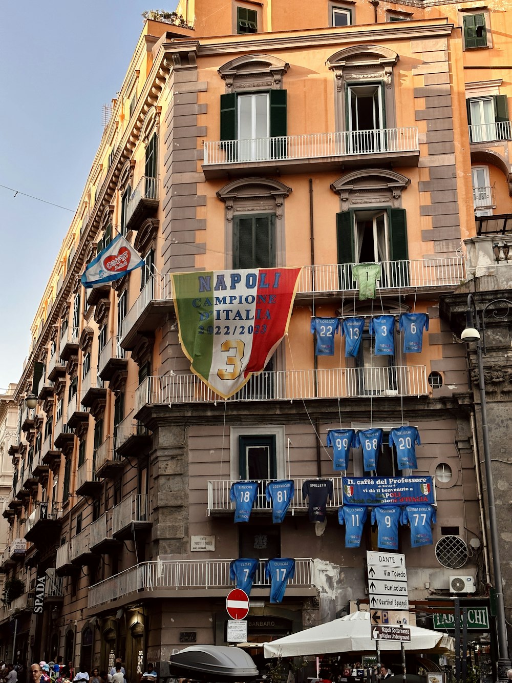 a tall building with a bunch of flags hanging from it's sides