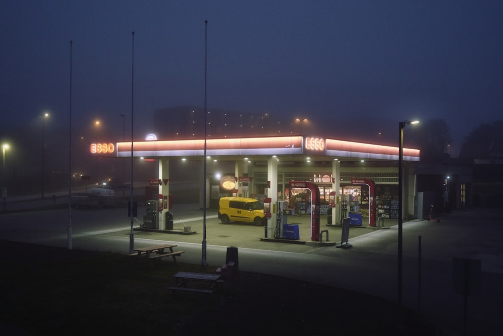a gas station at night with a yellow truck