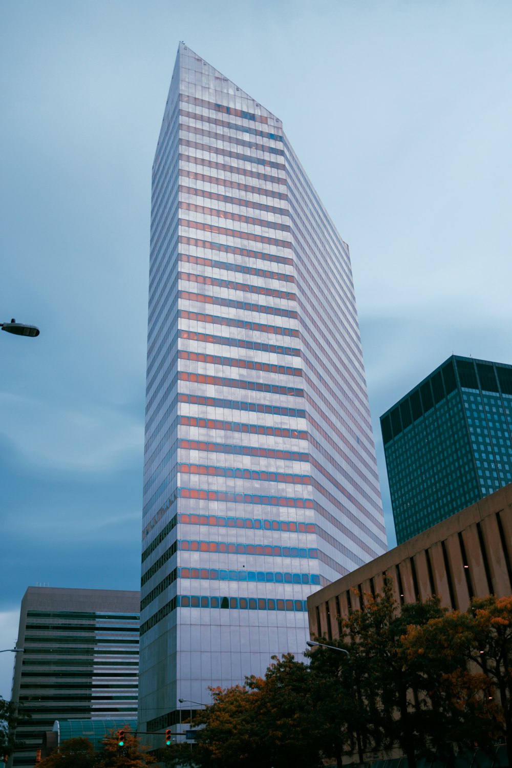 a tall building with a plane flying in the sky