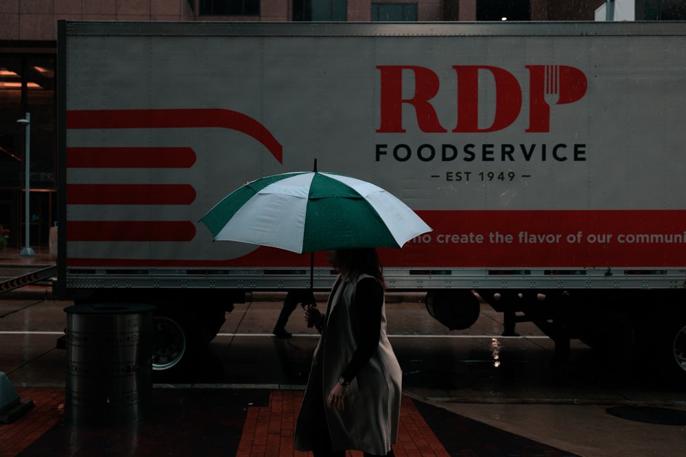 a woman walking down a street holding an umbrella