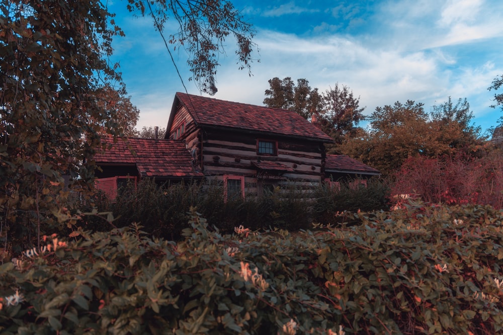 a log cabin in the woods with a red roof