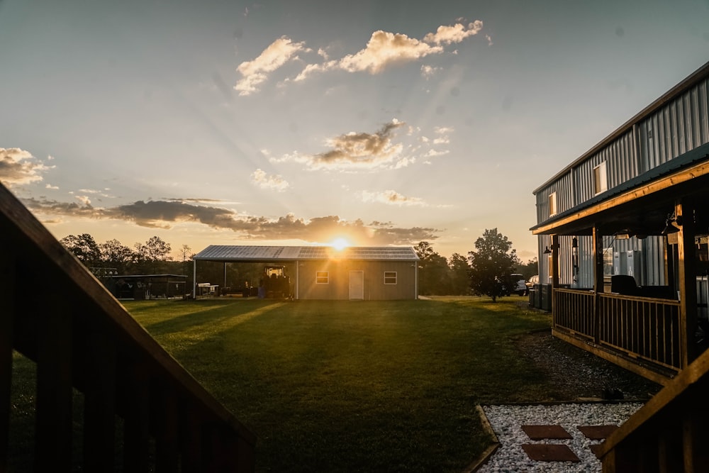 the sun is setting over a small house