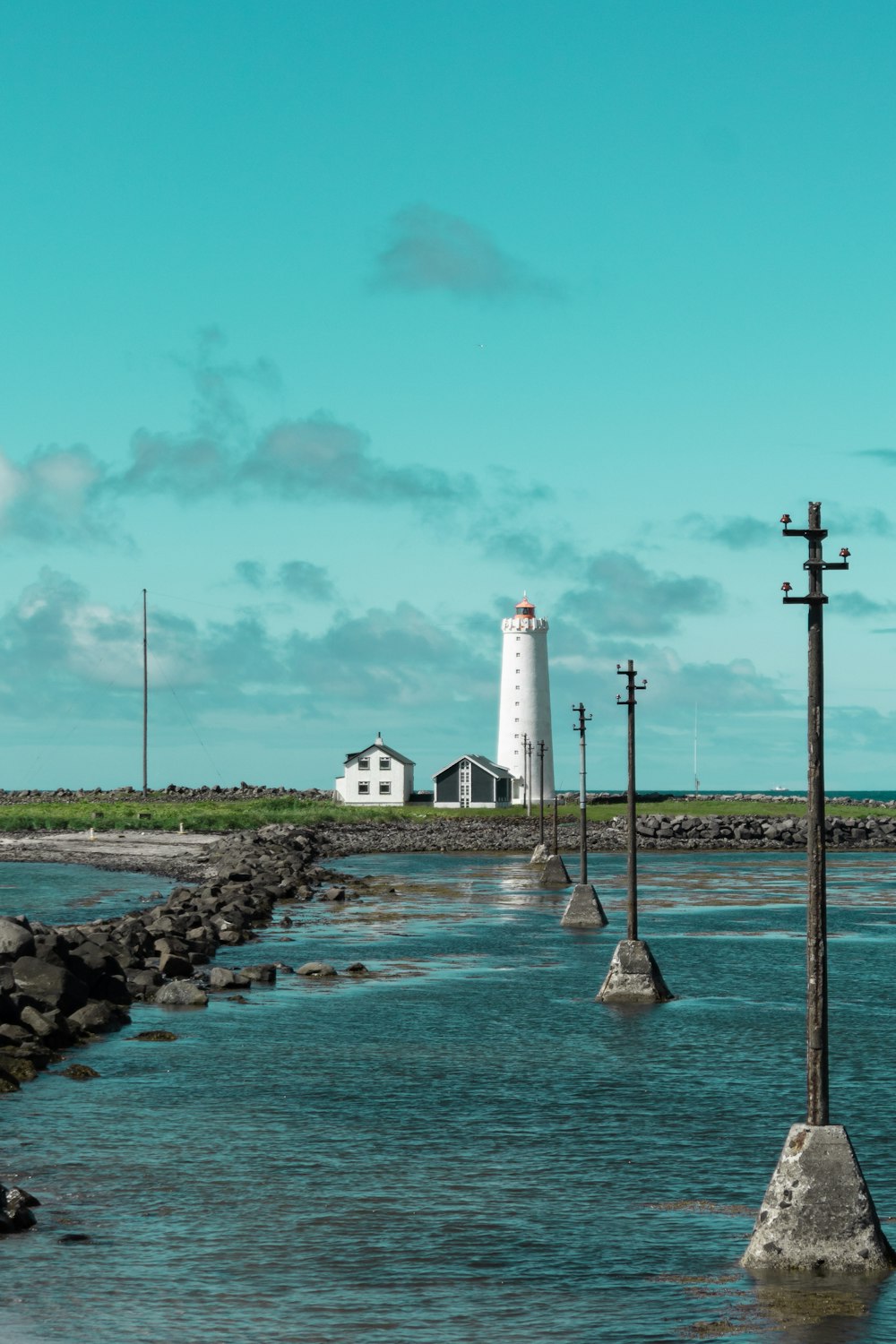 a body of water with a lighthouse in the background