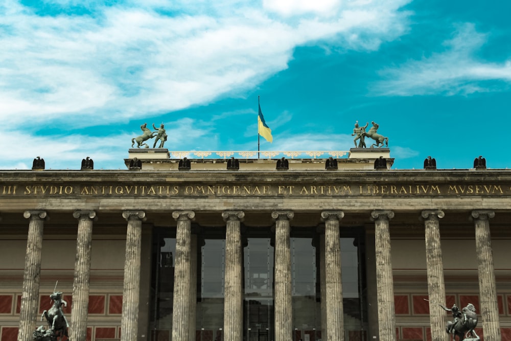 a large building with columns and statues on top of it