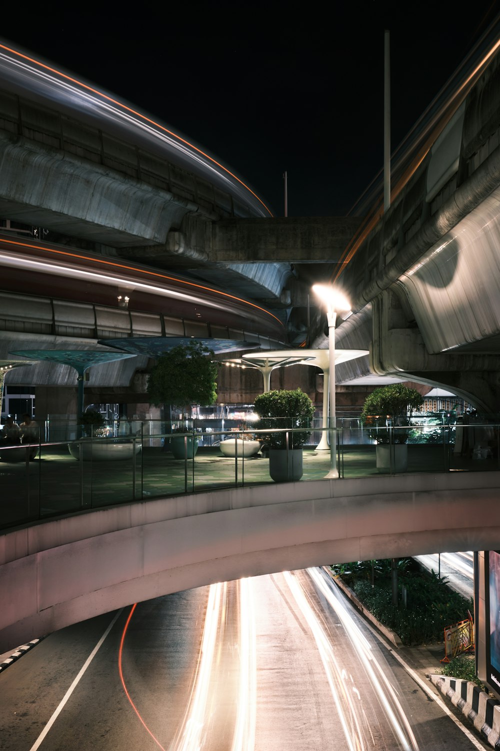 a city street at night with a bridge and traffic lights