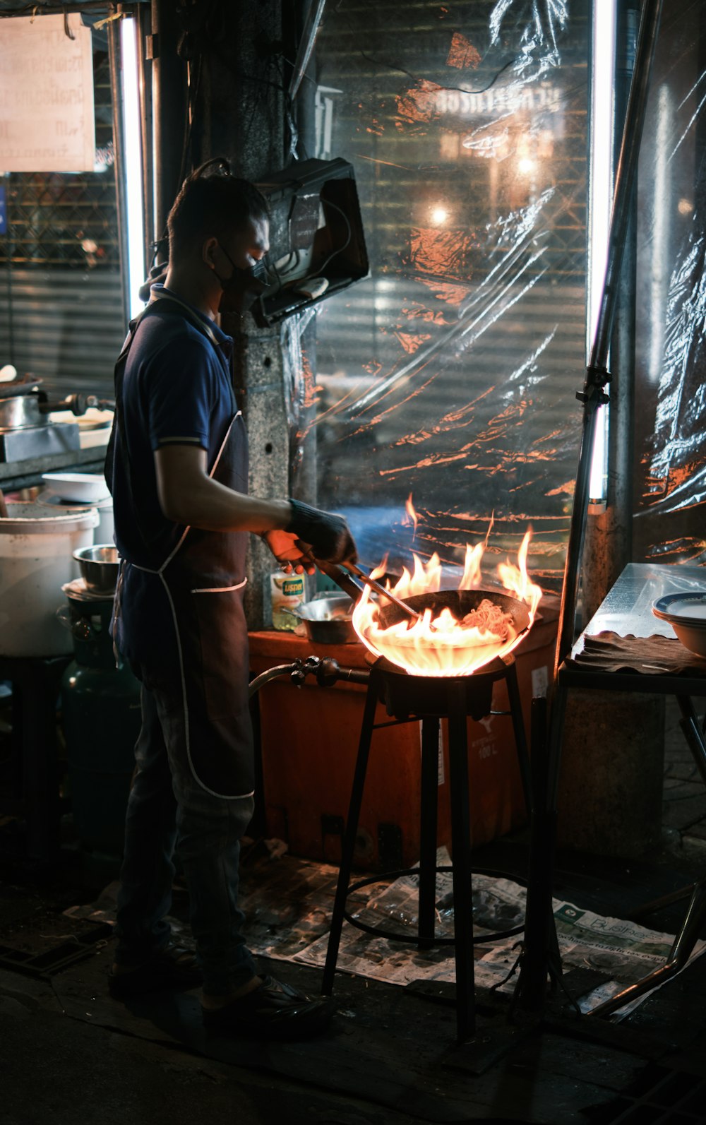 a man standing over a fire in a kitchen