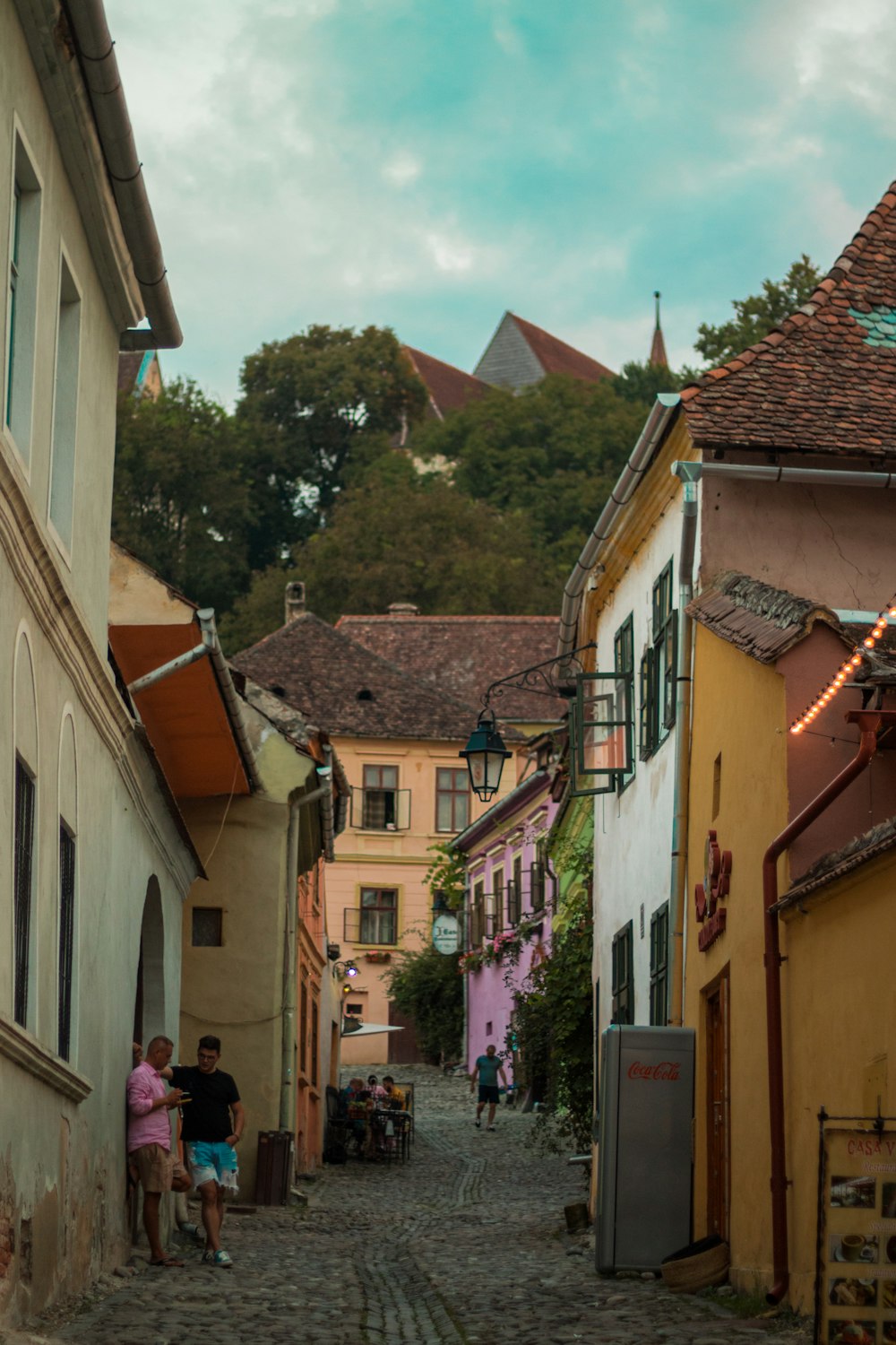 a cobblestone street lined with buildings and people