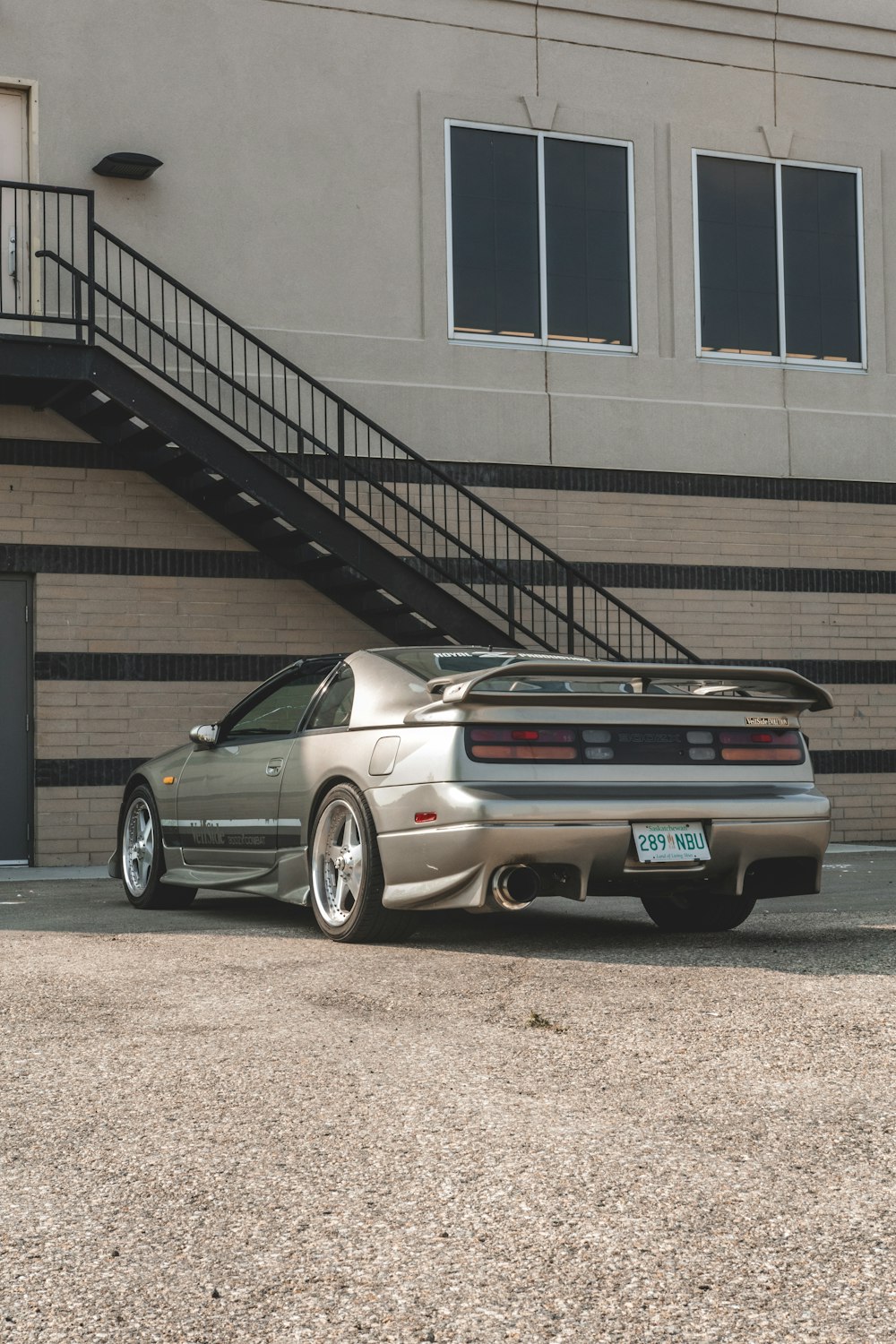 a silver sports car parked in front of a building