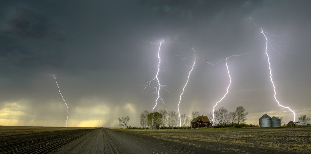 a lightning storm is seen over a farm field