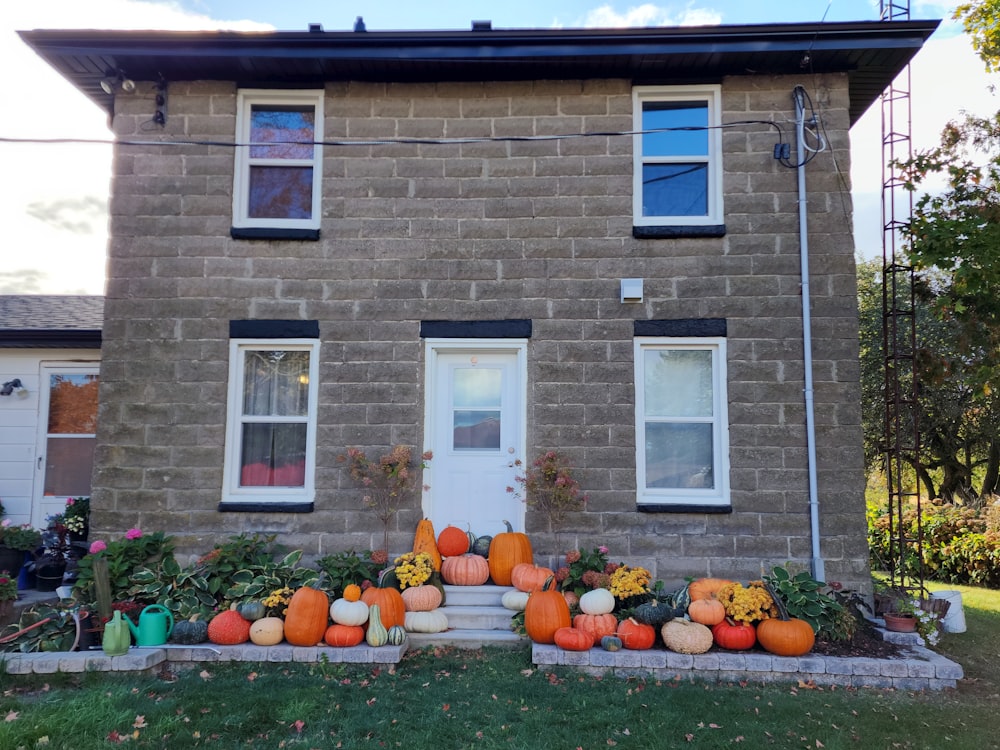 a house with pumpkins and gourds in front of it