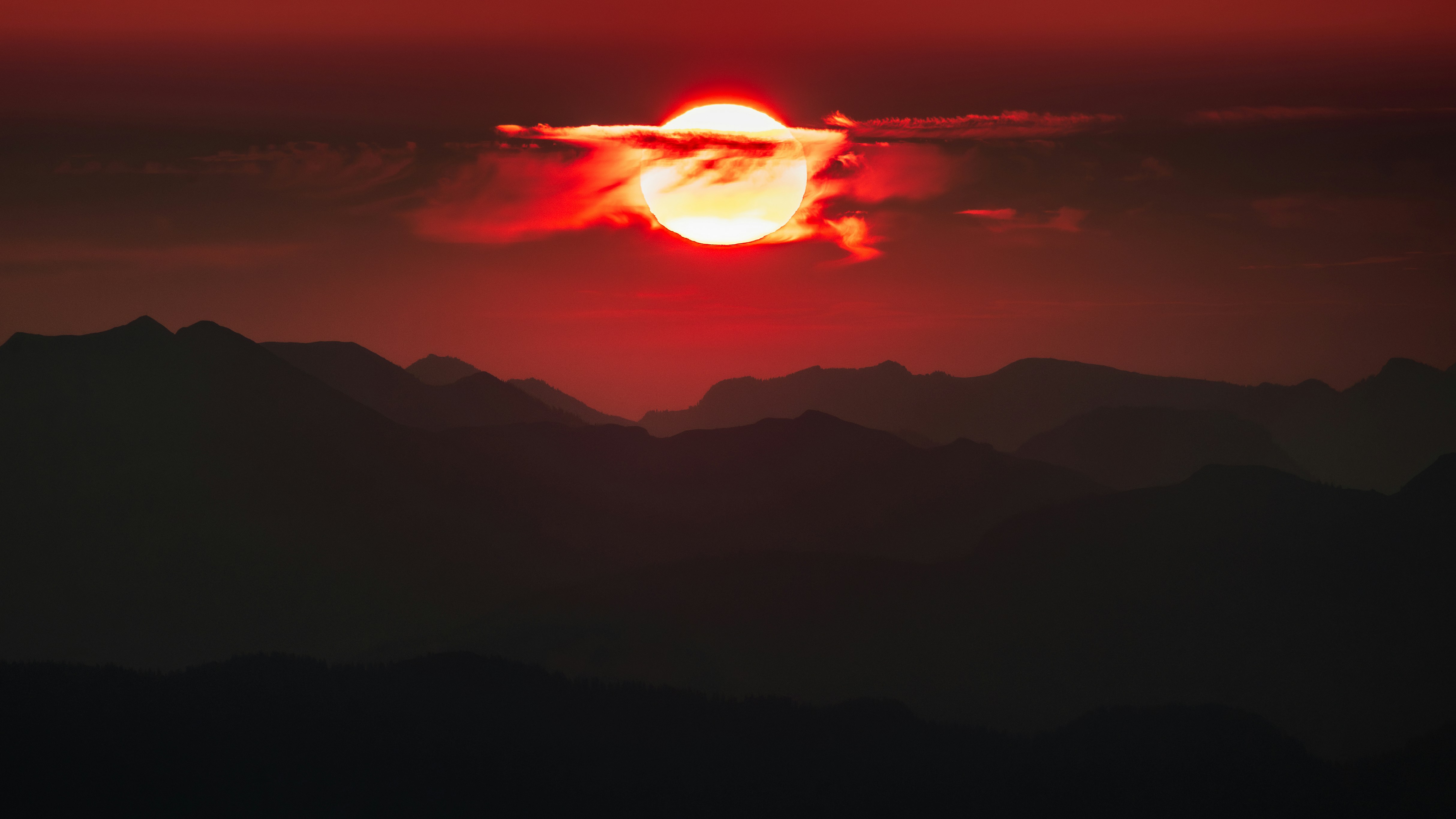 the sun is setting over a mountain range