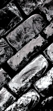 Detail shot of metallic brush strokes with reflective highlights on a dark background.