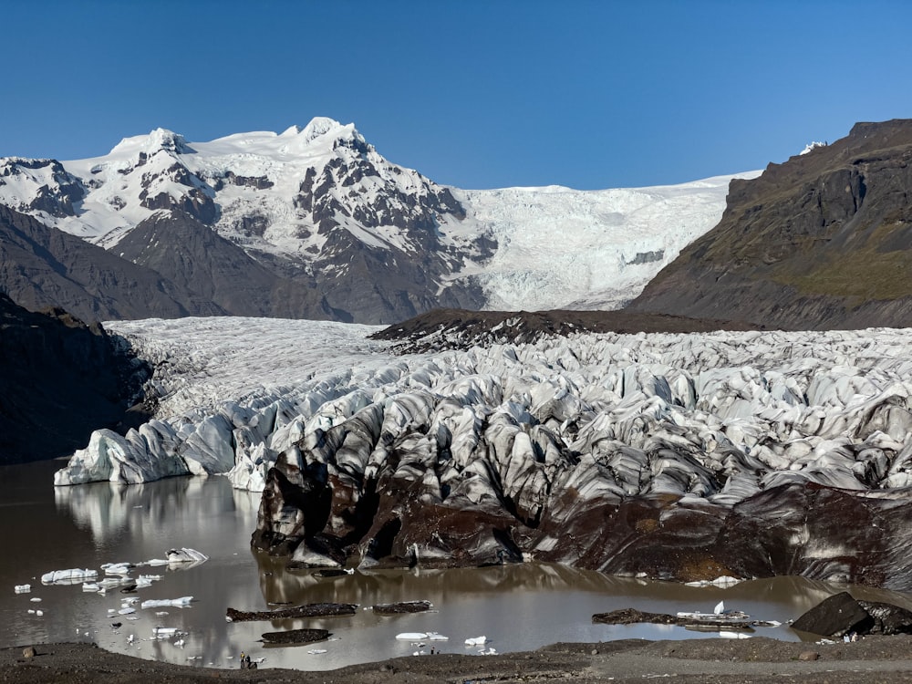 a large glacier with mountains in the background