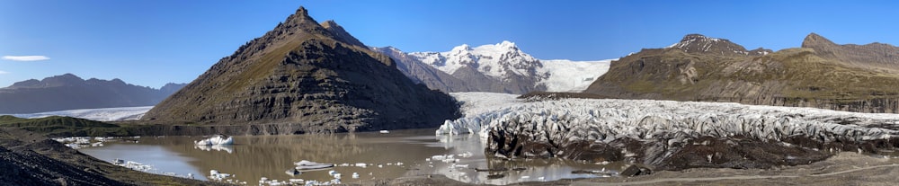 un groupe de montagnes qui sont à côté d’un plan d’eau