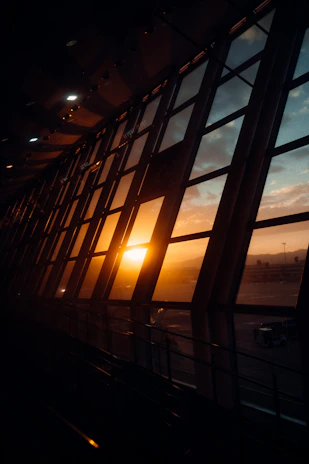 A panoramic view of the Stargate Holding headquarters building at sunset, with warm lights glowing through the windows.