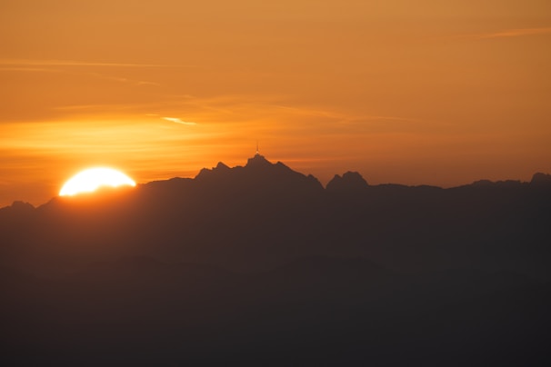 A vibrant sunset viewed from a mountain peak.