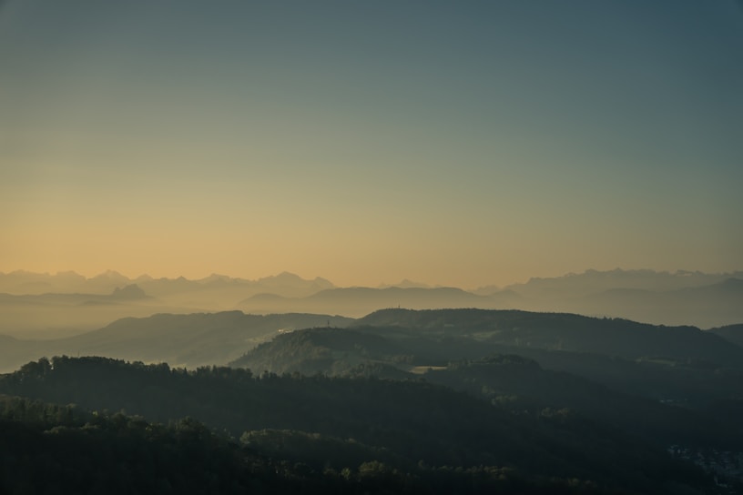 A serene landscape of rolling hills at sunrise.