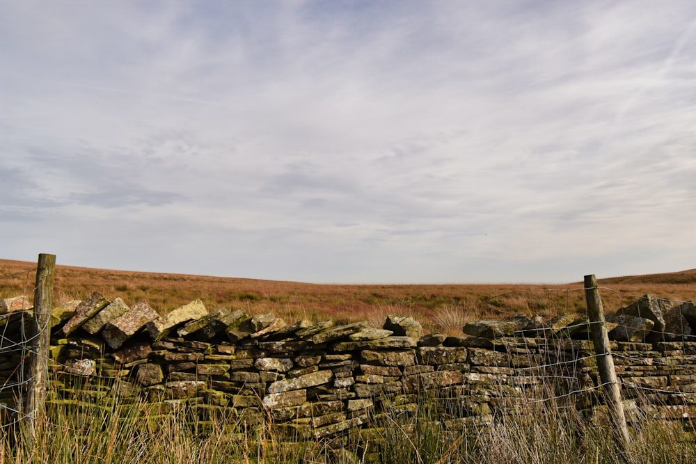 a stone wall in the middle of a field