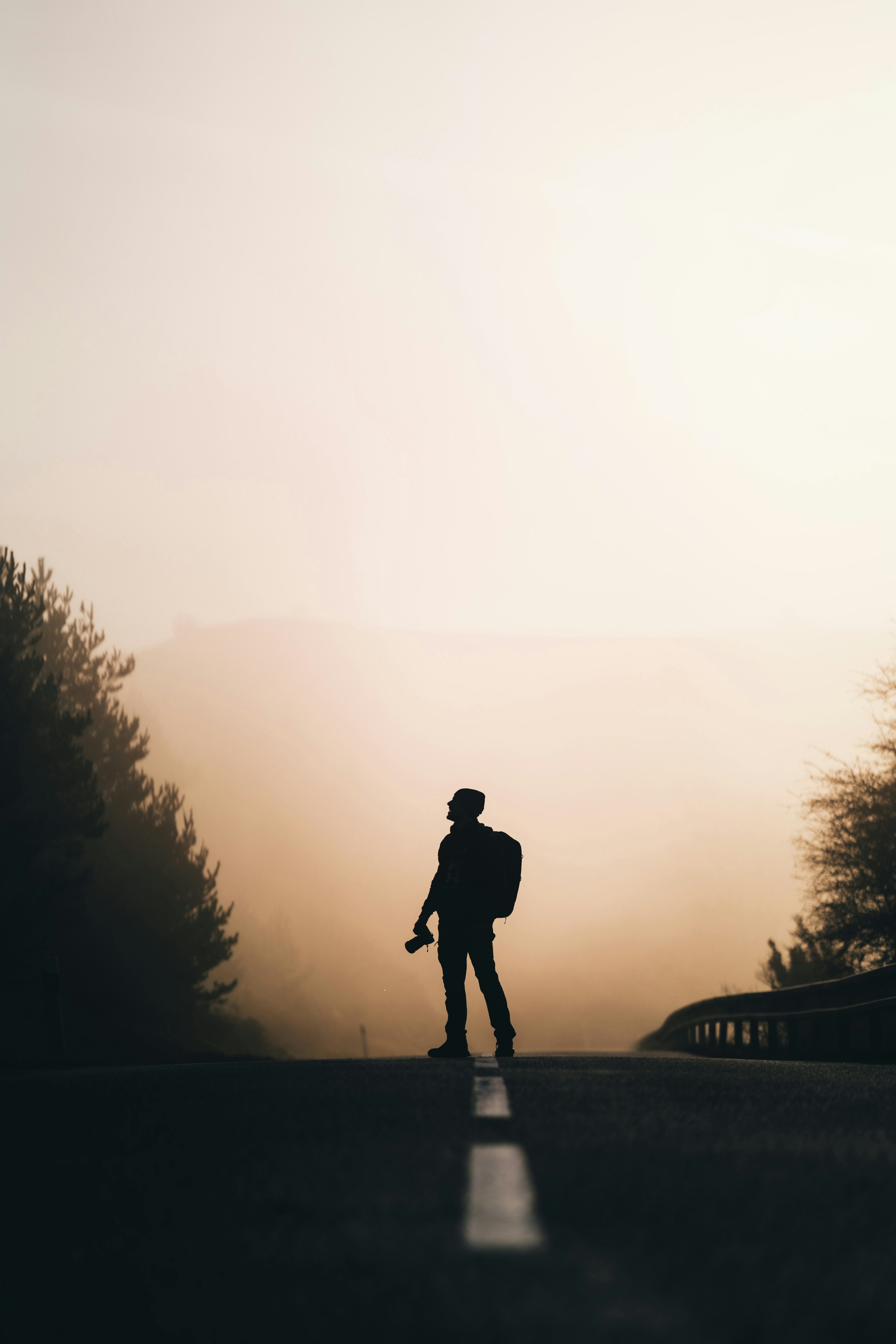 a person with a backpack standing on a road