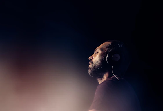 a man with headphones standing in the dark