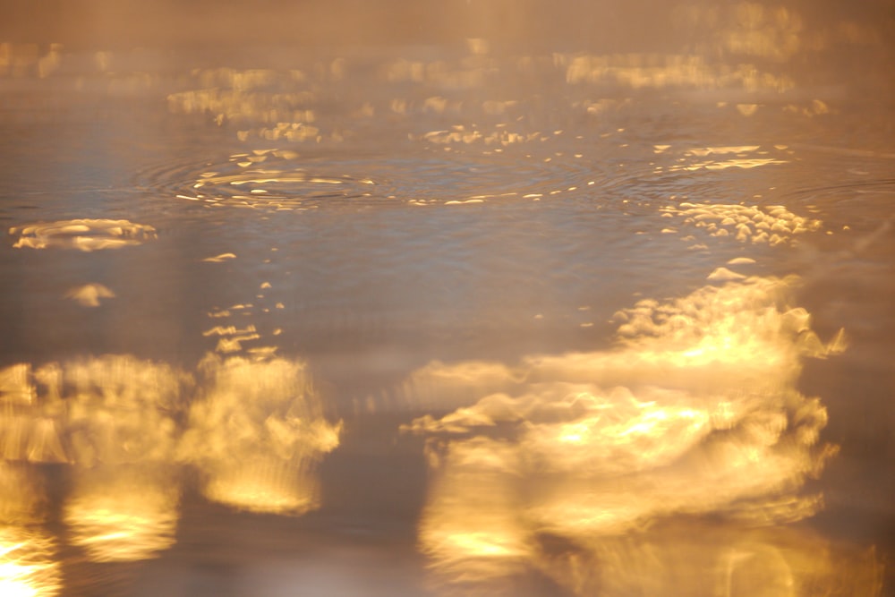 the sun is shining through the clouds in the water