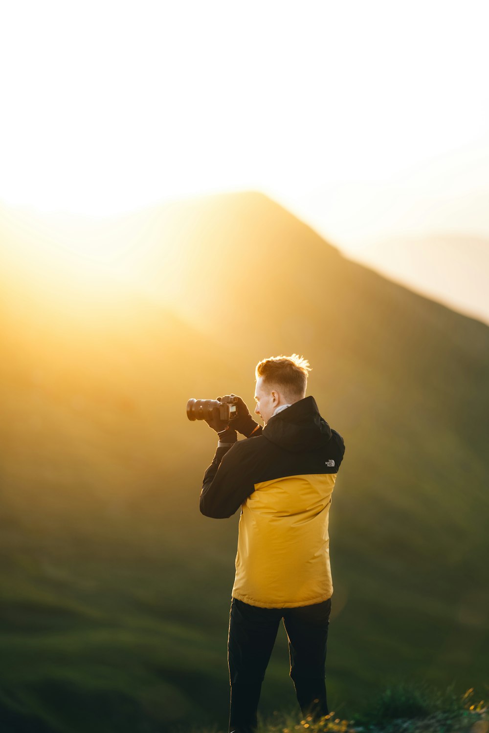 a man taking a picture of the sun with his camera